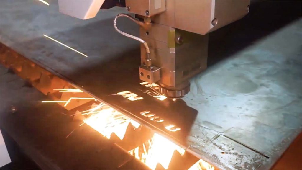Detail kepala mesin cutting laser Raytools yang sedang bekerja presisi memotong bahan untuk kebutuhan industri