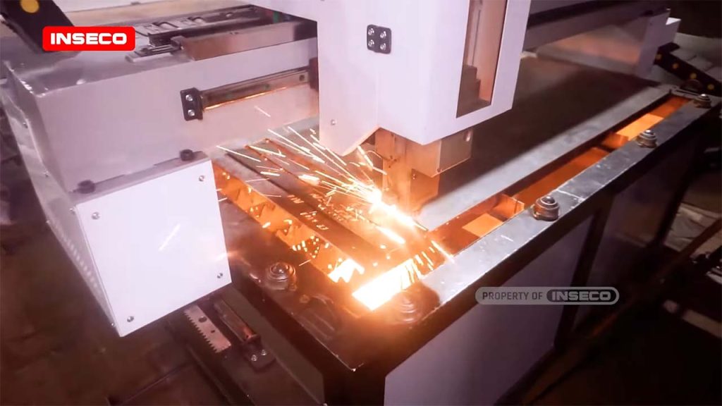 Detail kepala mesin cutting laser merk INSECO yang sedang bekerja memotong material metal dengan cepat dan akurat
