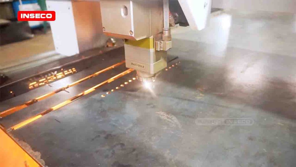 Kepala laser Raytools pada mesin CNC laser cutting Inseco memotong plat besi, terlihat cahaya kuat dan percikan api dari proses pemotongan